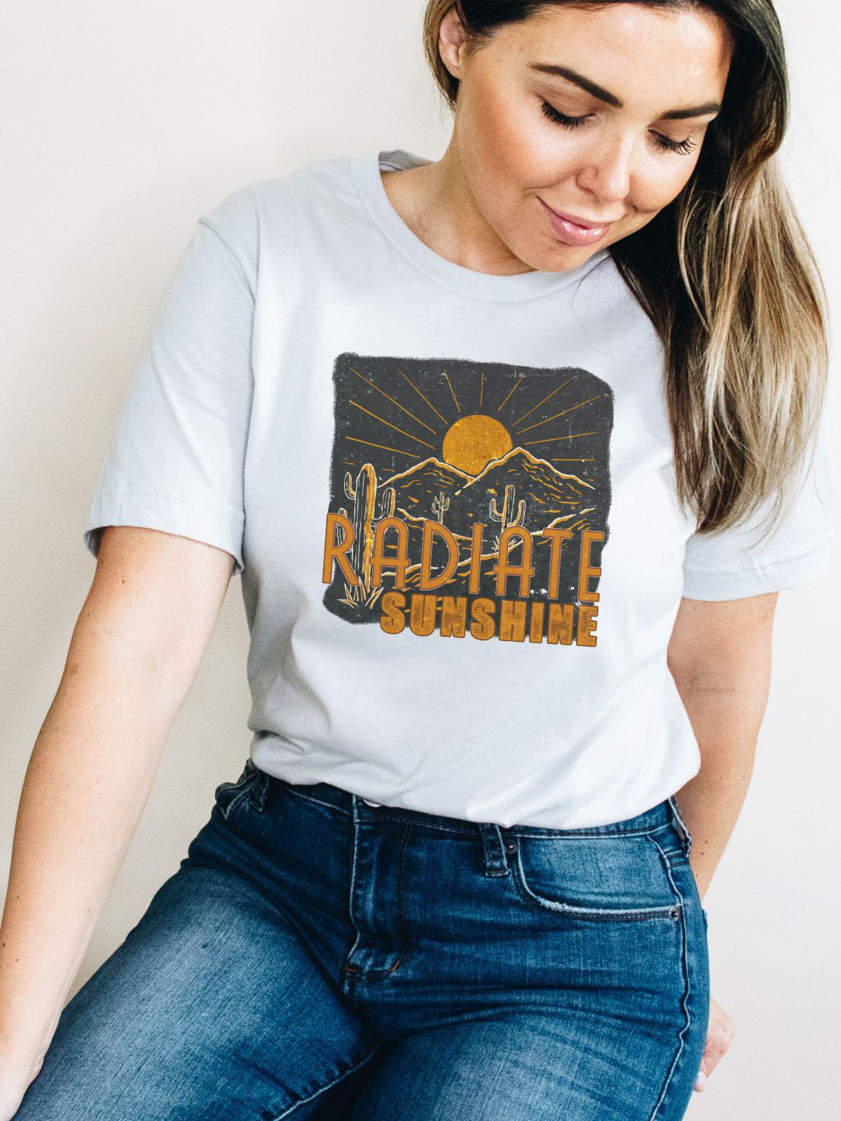 woman wearing Radiate Sunshine t-shirt with sun and cactus design