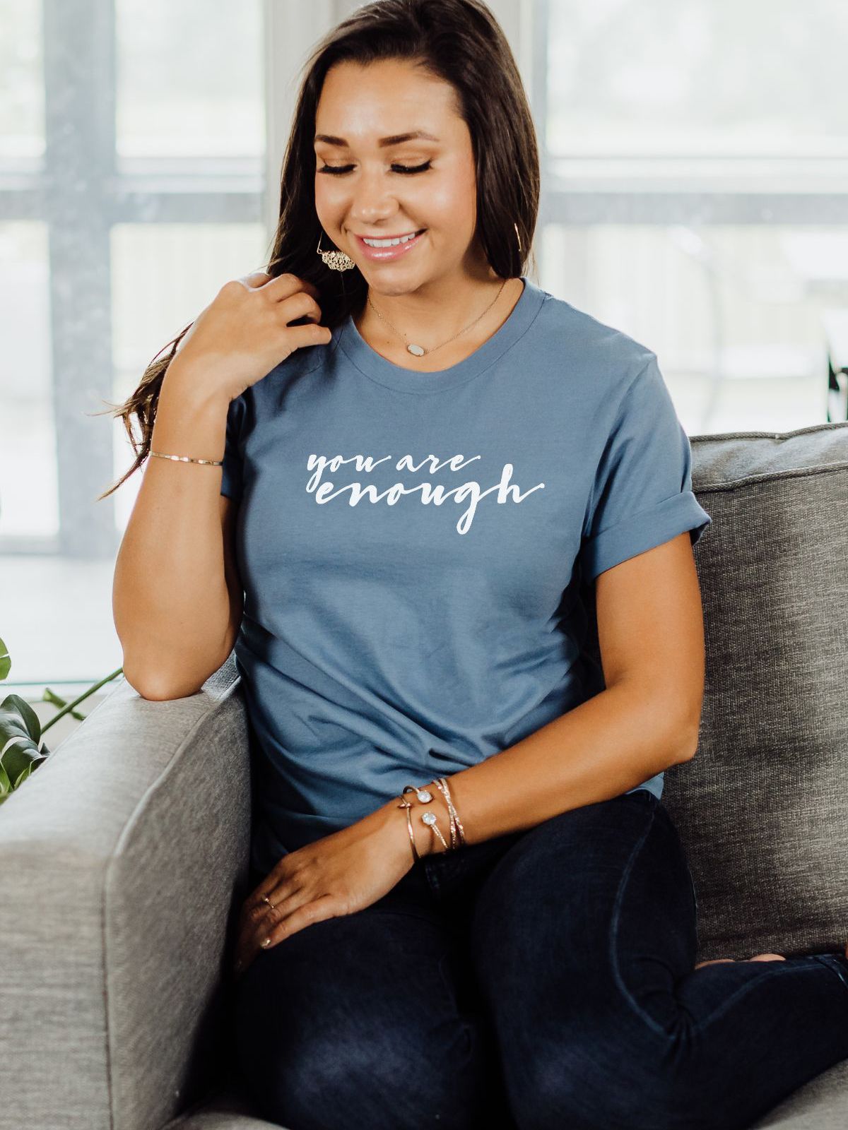 Woman wearing a blue t-shirt with 'You Are Enough' printed on it