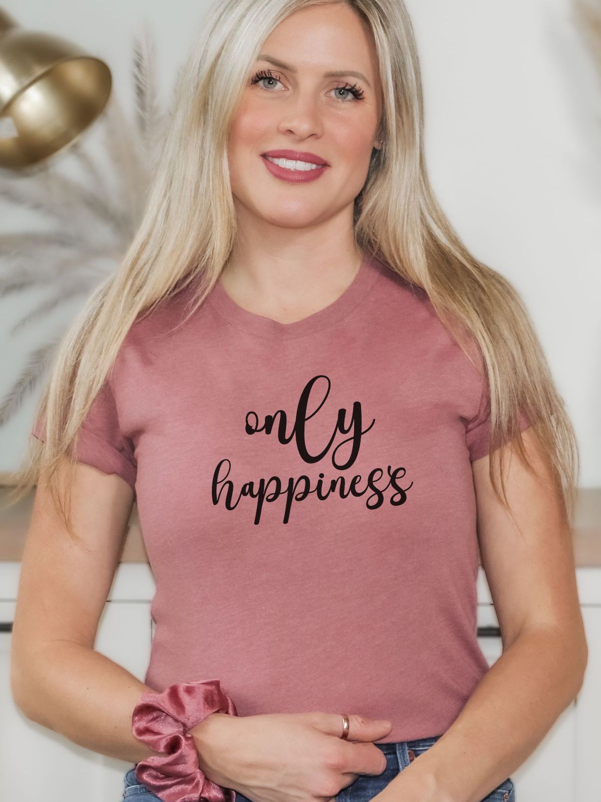 Woman wearing pink t-shirt with only happiness text