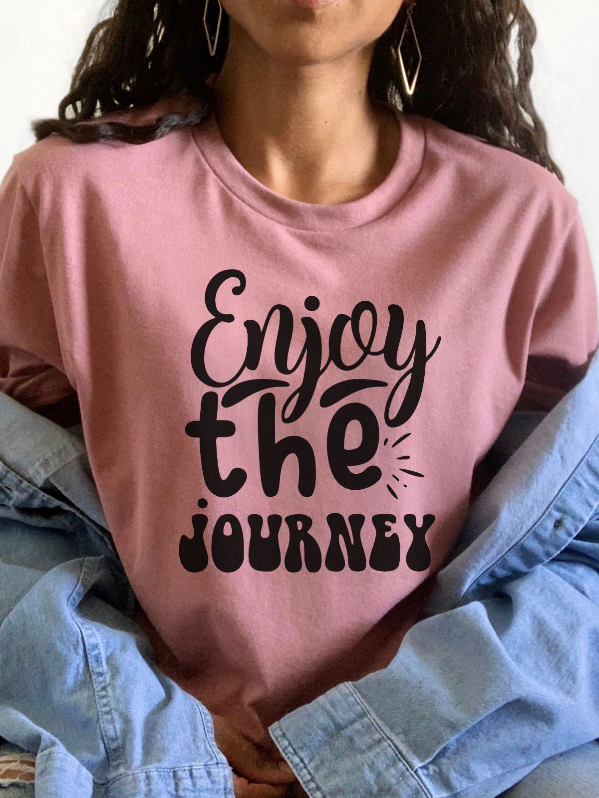woman wearing a pink t-shirt with enjoy the journey text