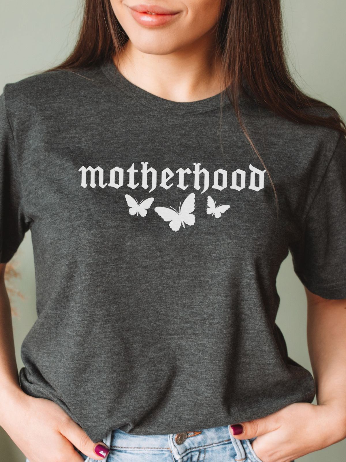 woman wearing a dark gray t-shirt with motherhood and butterfly design
