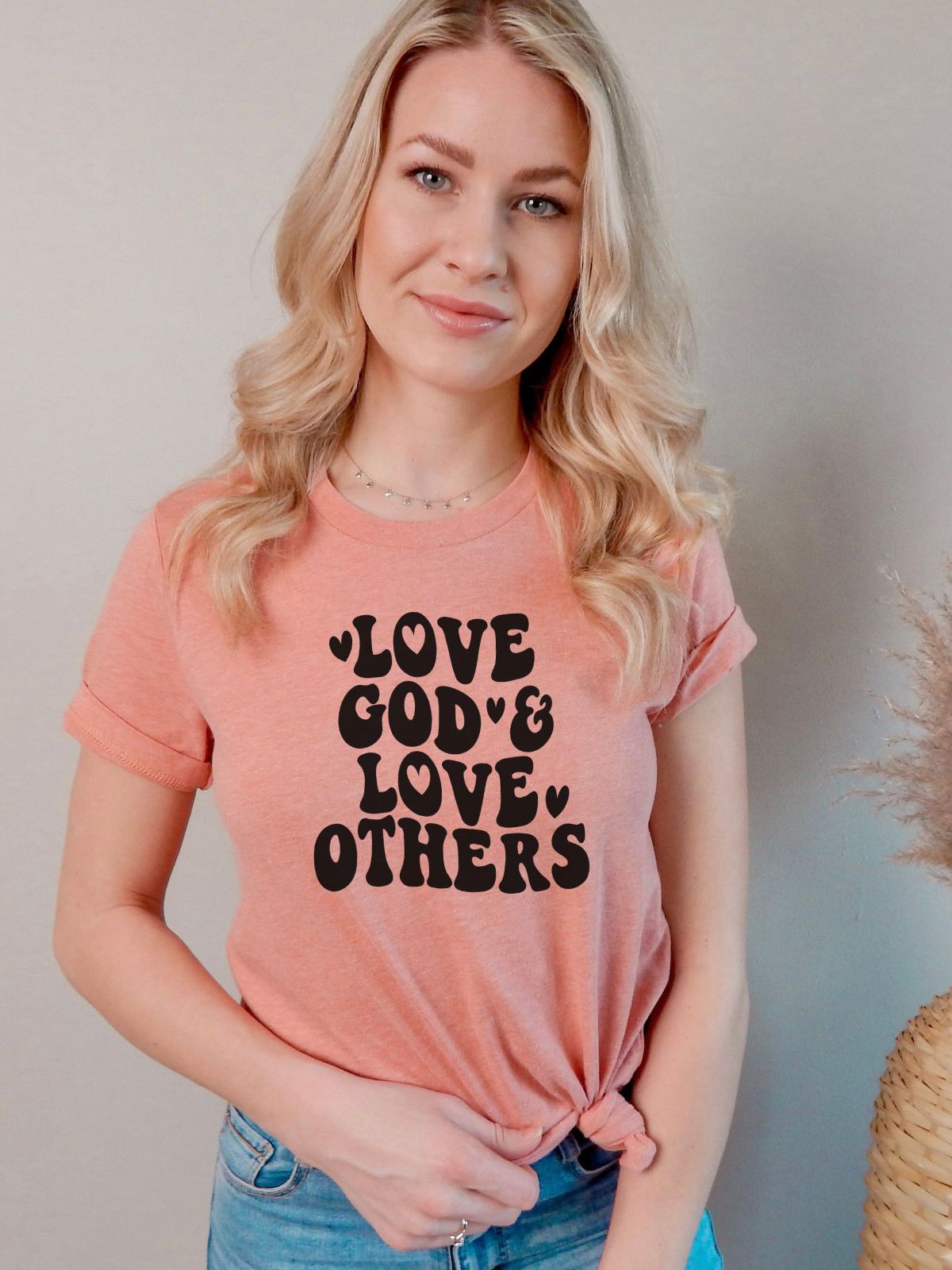 woman wearing a Love God and Love Others peach t-shirt