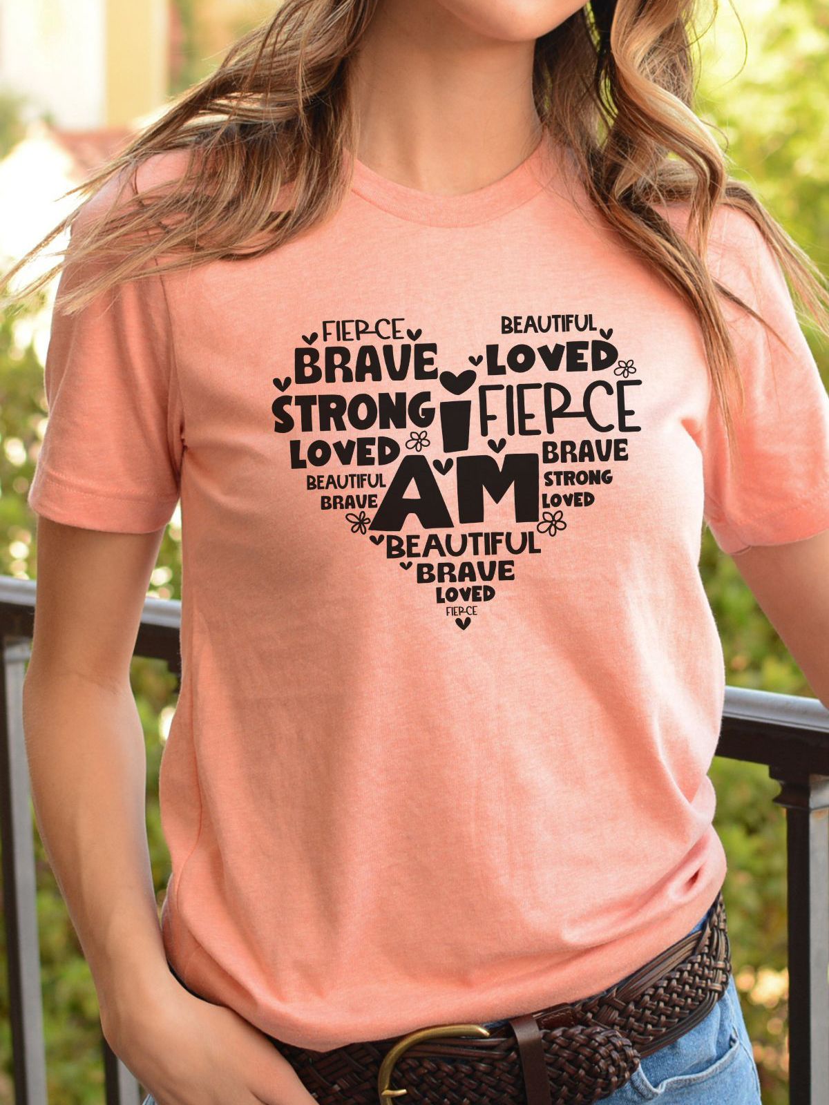 Pink t-shirt with inspirational heart design featuring words brave and loved