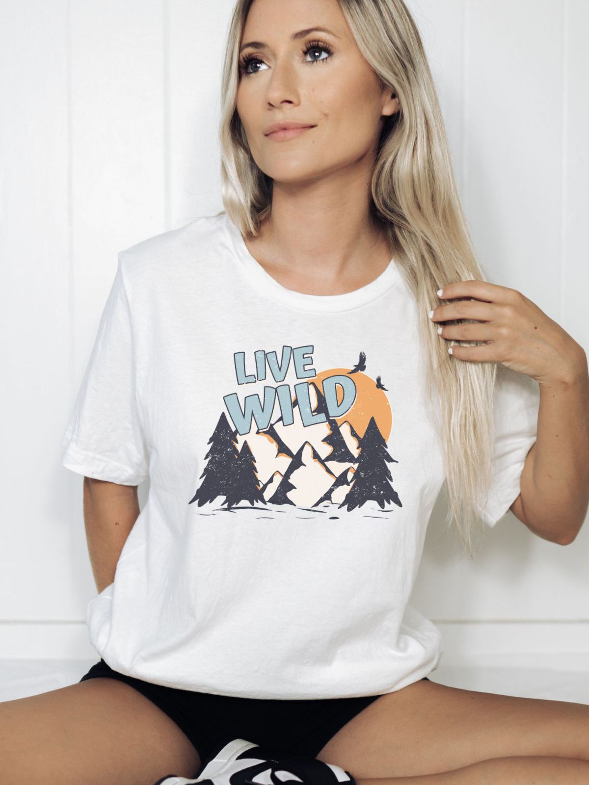 Woman wearing Live Wild t-shirt with mountain design