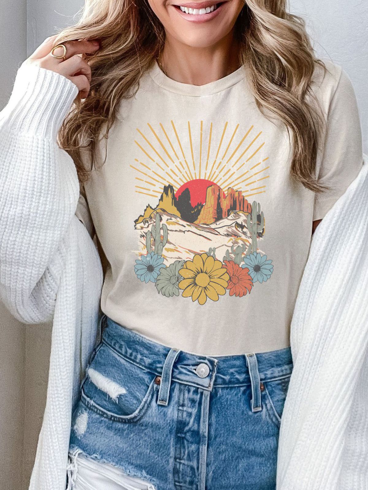 woman wearing t-shirt with desert sunset and flowers