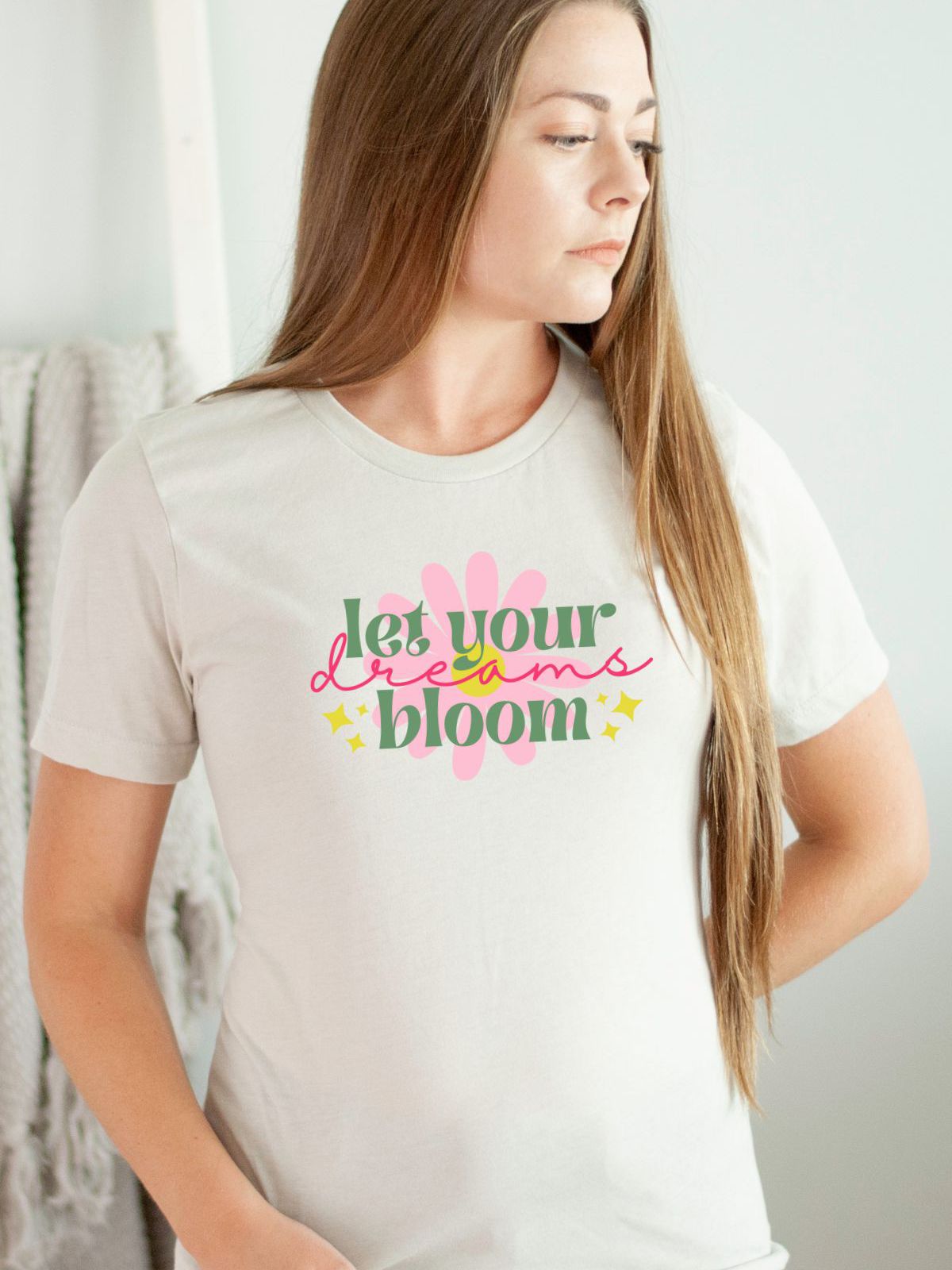 woman wearing a white t-shirt with let your dreams bloom design