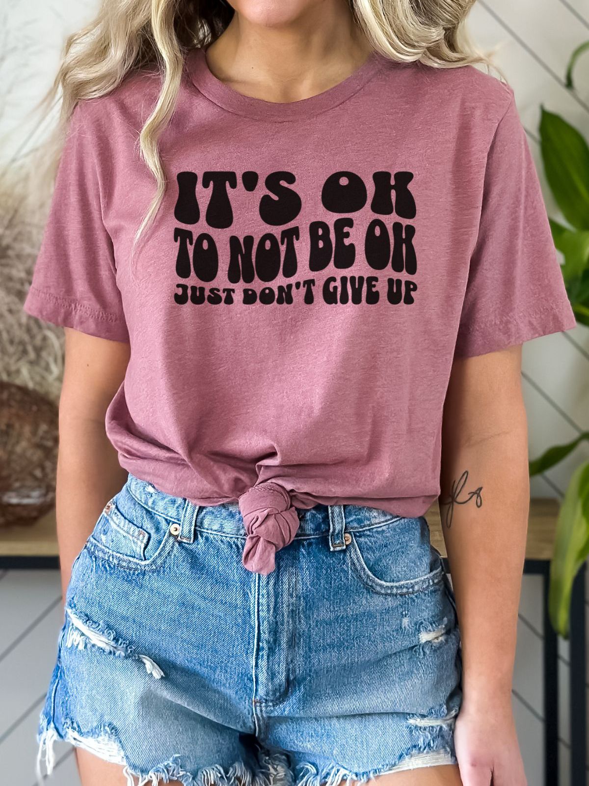 woman wearing a pink t-shirt with inspiring text