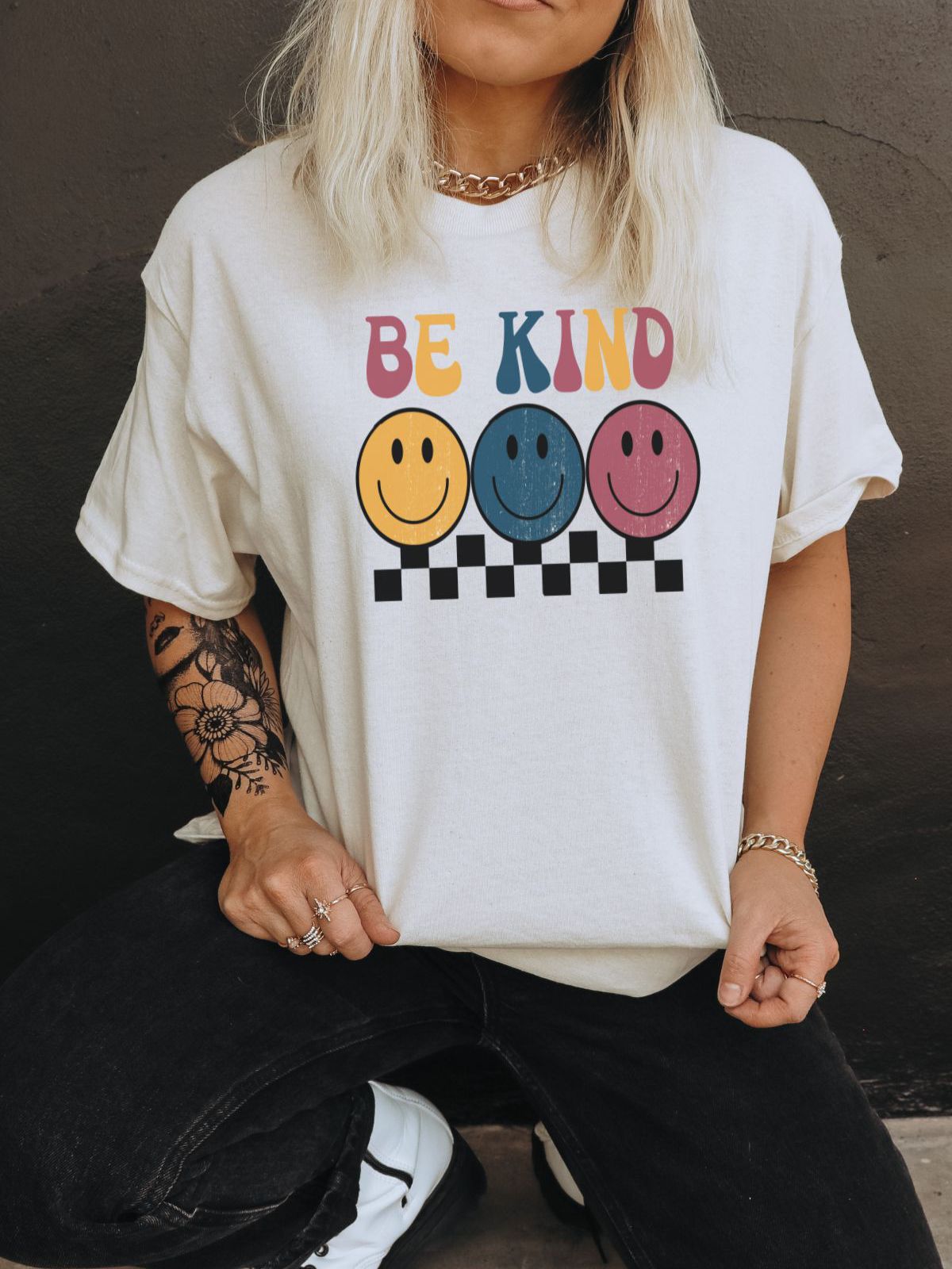 woman wearing a be kind graphic t-shirt with smiley faces