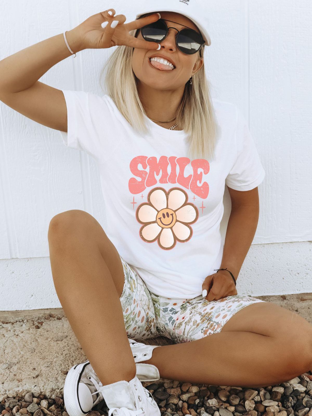 woman wearing a white t-shirt with smile flower design