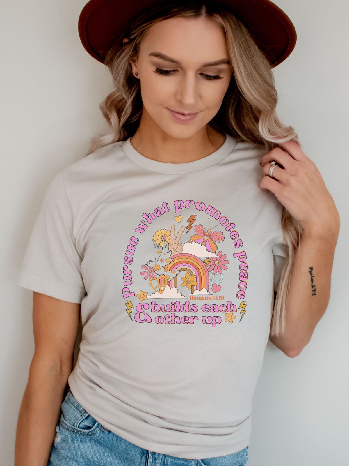 woman wearing graphic tee with rainbow and peace symbols