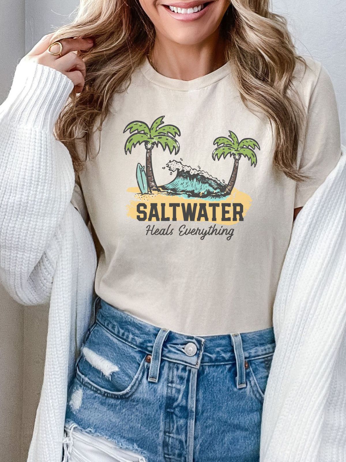 woman wearing t-shirt with saltwater heals everything design