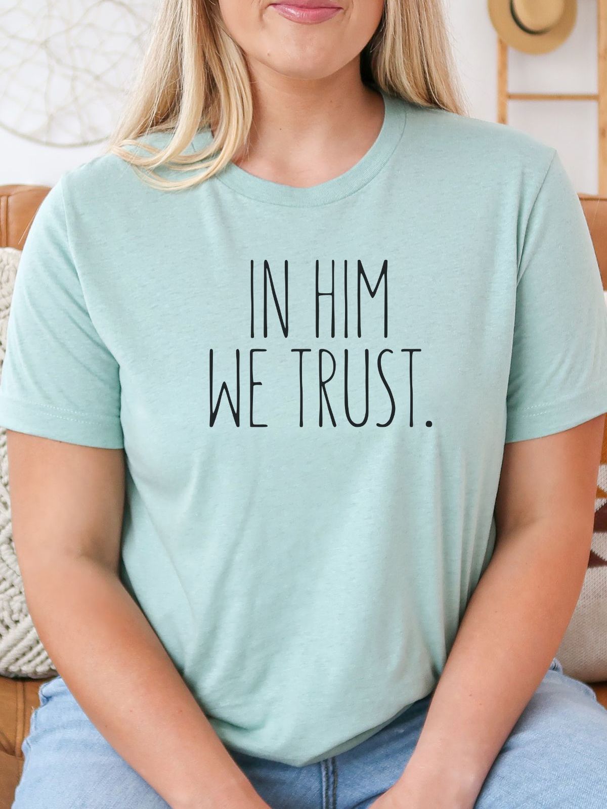 woman wearing mint green t-shirt with In Him We Trust text