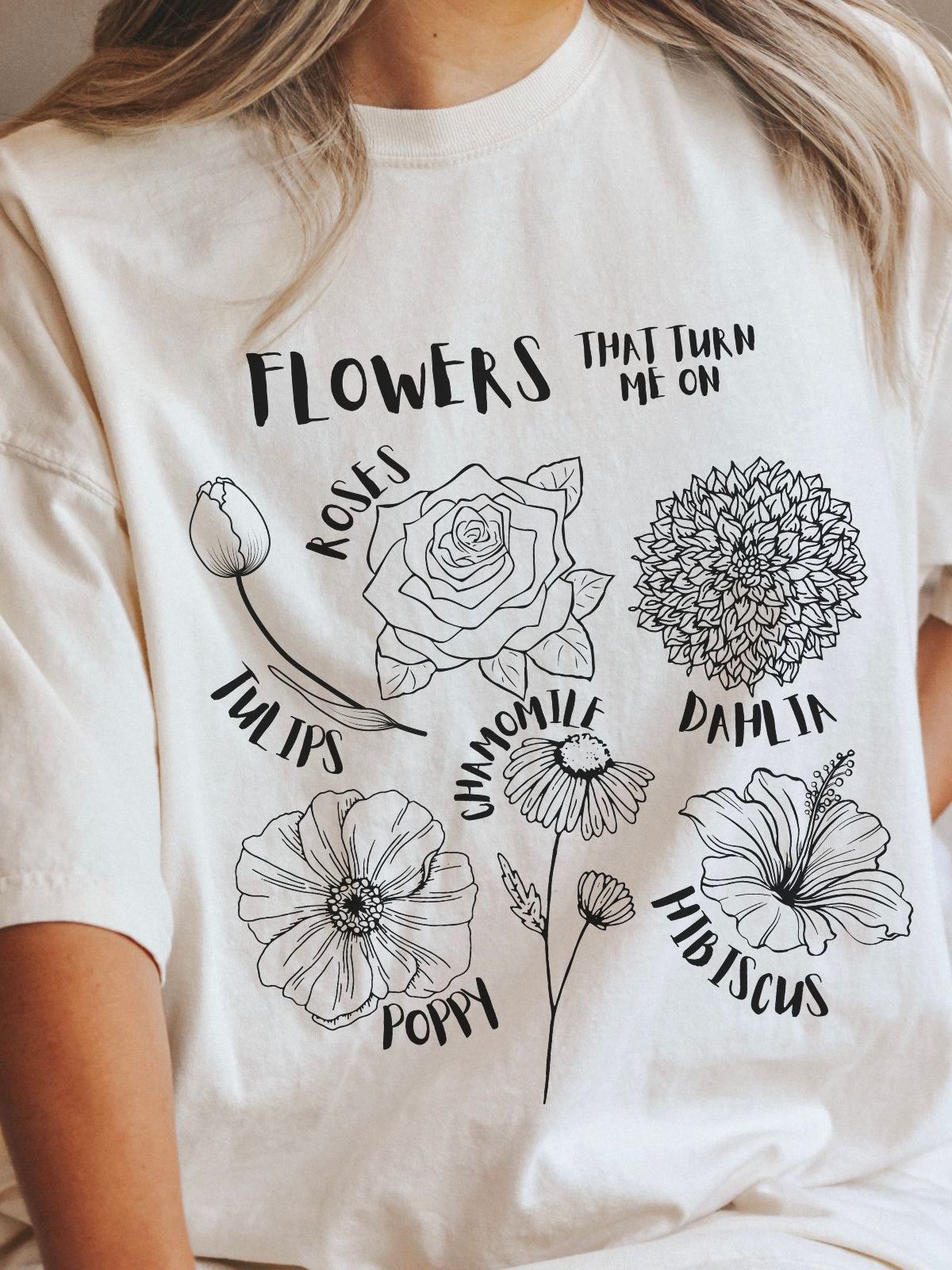 woman wearing t-shirt with floral designs and text flowers that turn me on