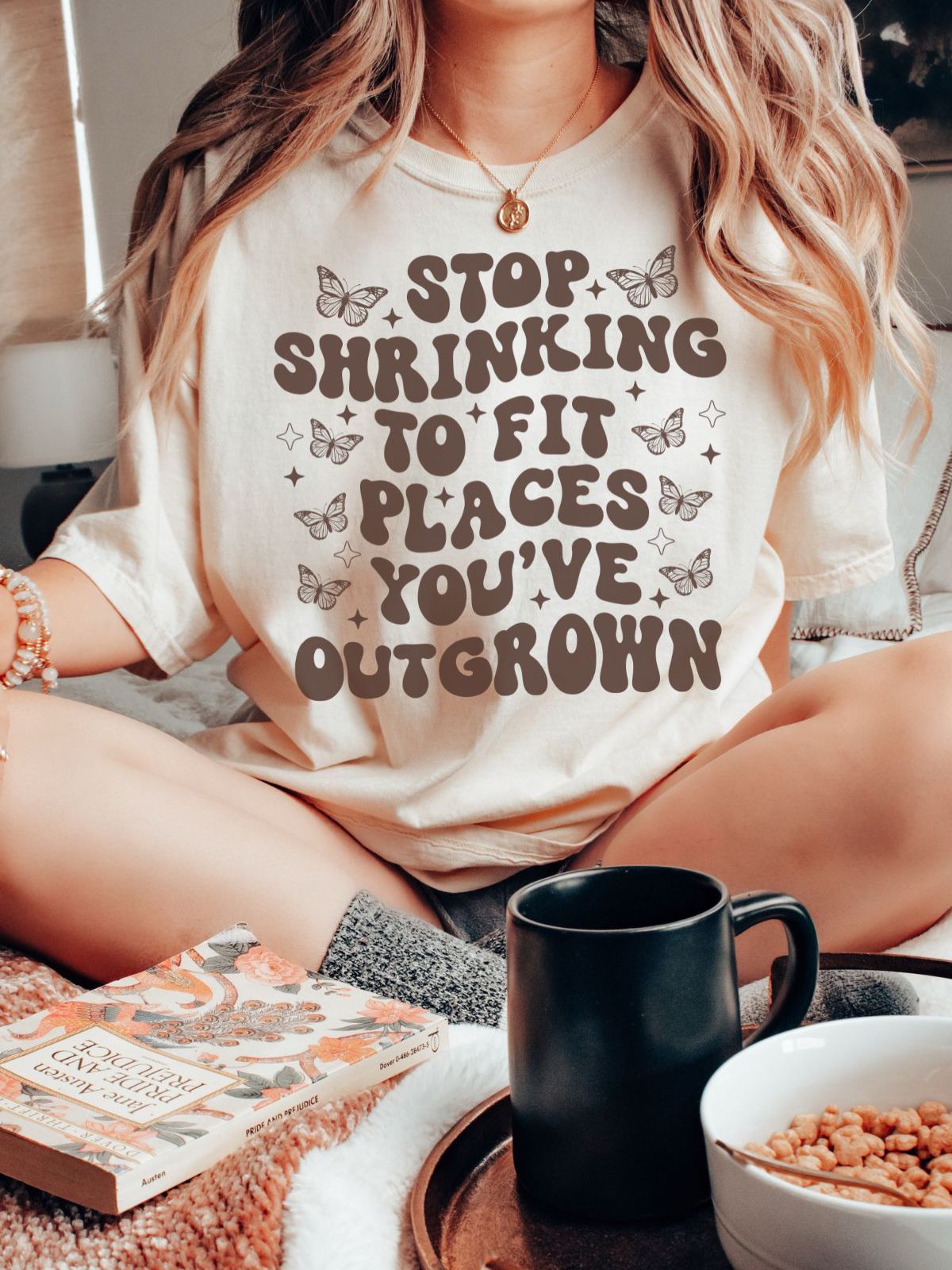 woman wearing t-shirt with stop shrinking to fit places you've outgrown design