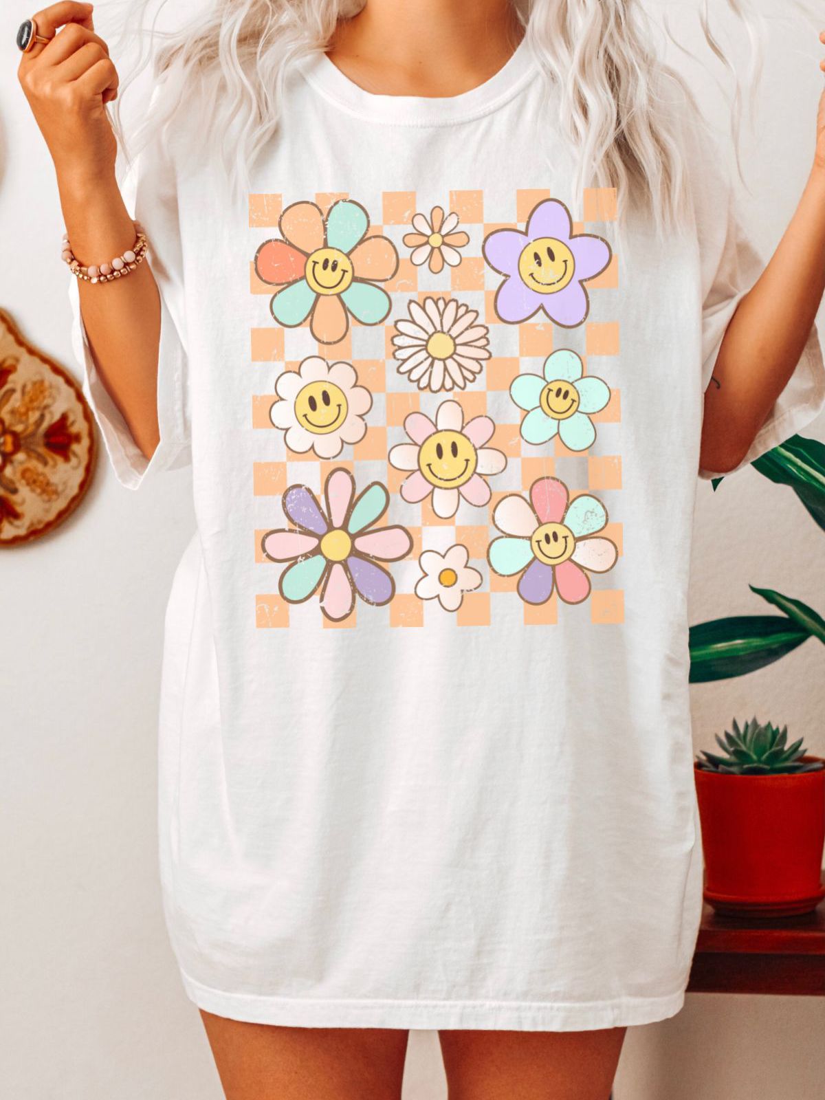 white t-shirt with smiley flower design in pastel colors