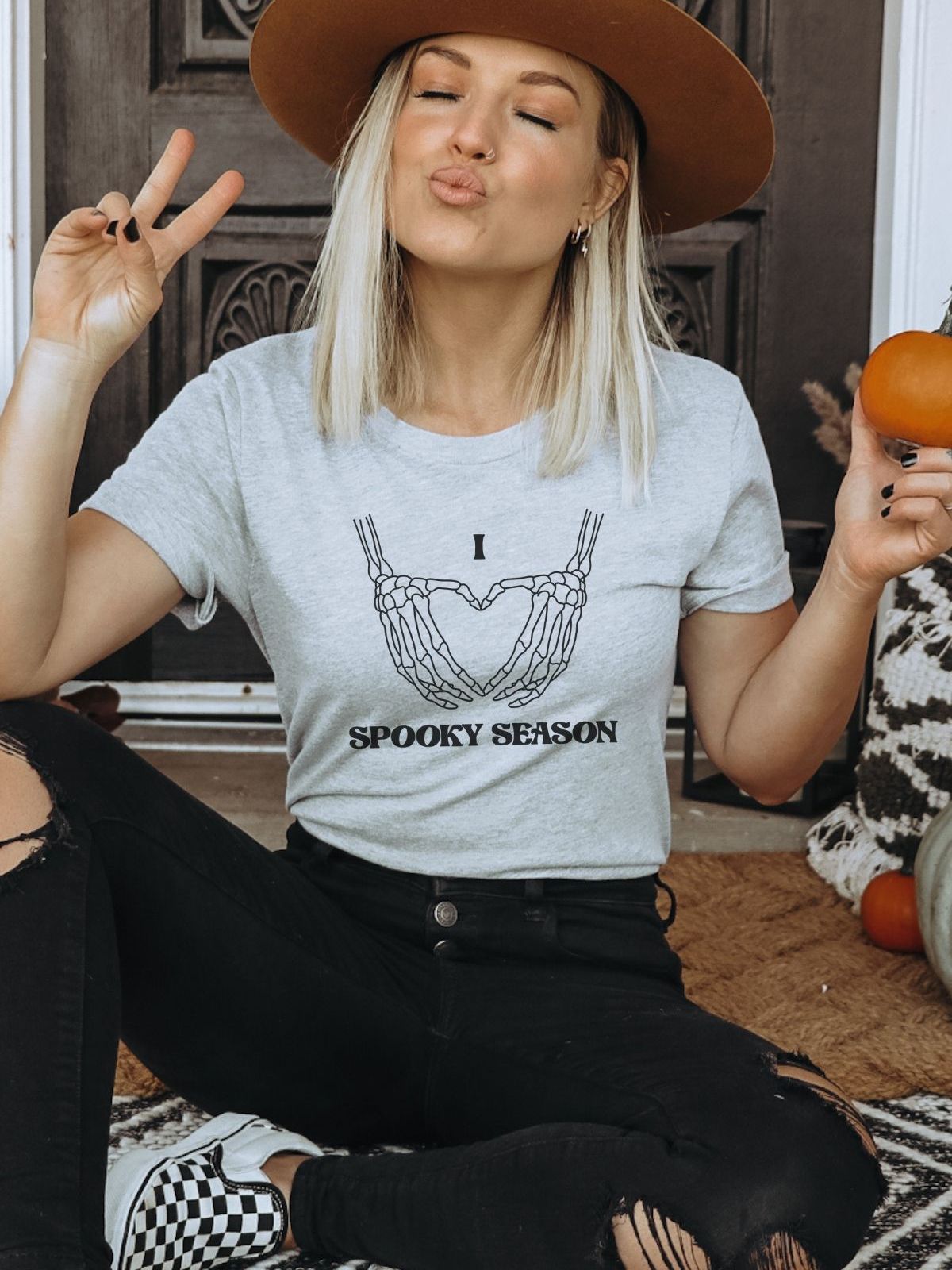 Woman wearing spooky season skeleton hands t-shirt