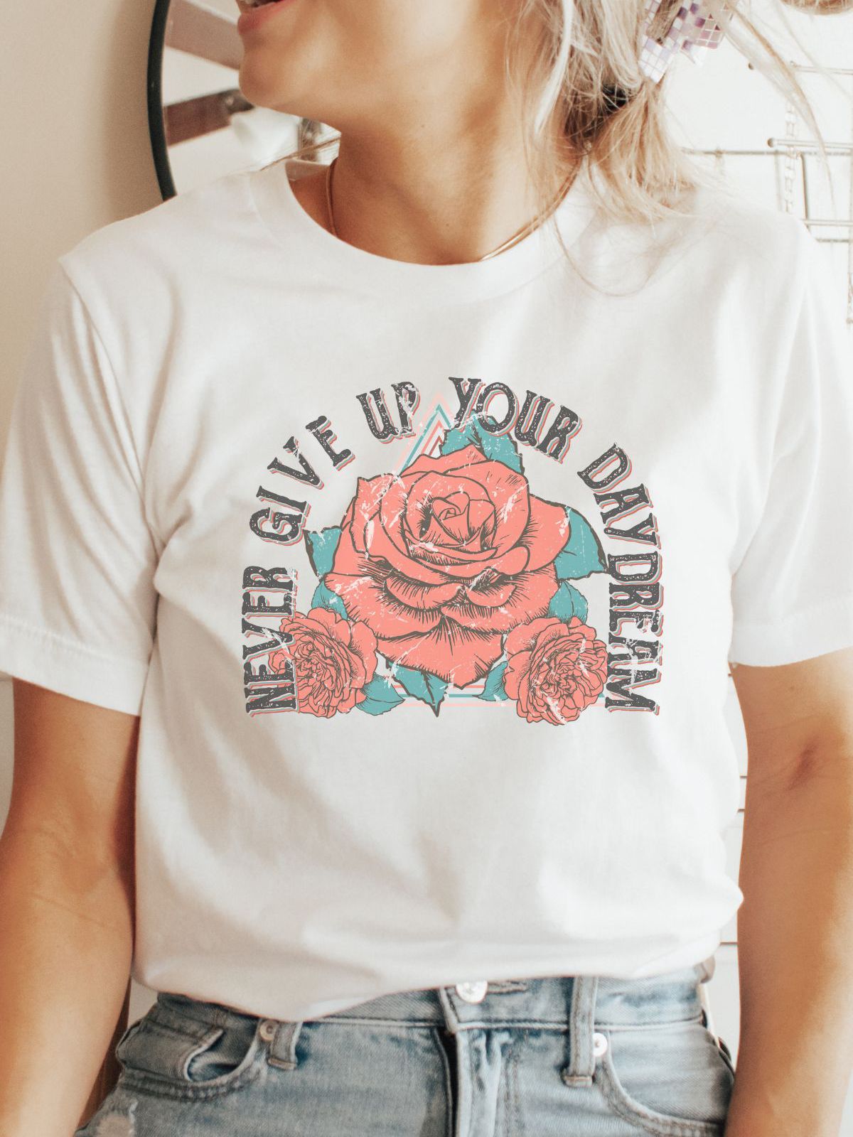 woman wearing a white tee with never give up your daydream and rose design