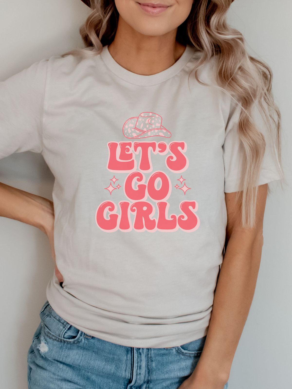 woman wearing a Let's Go Girls t-shirt with cowboy hat illustration