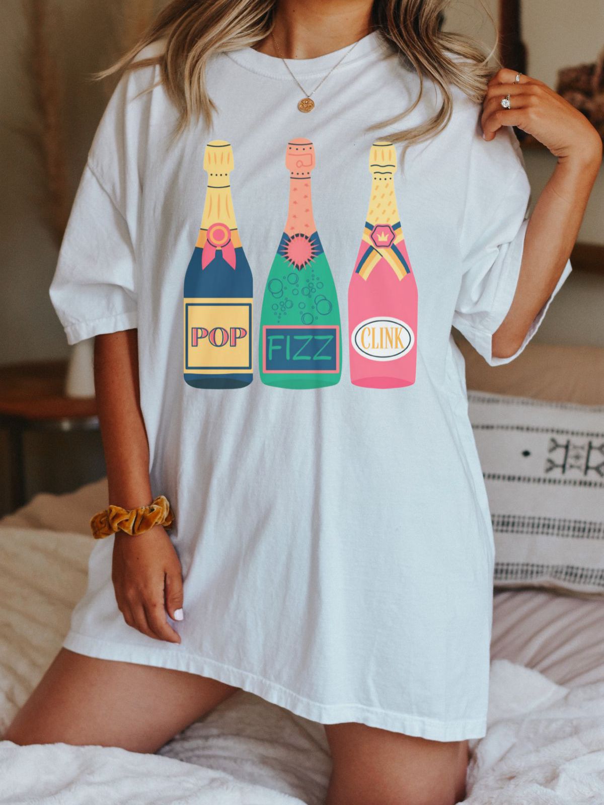 woman wearing pop fizz clink champagne graphic shirt