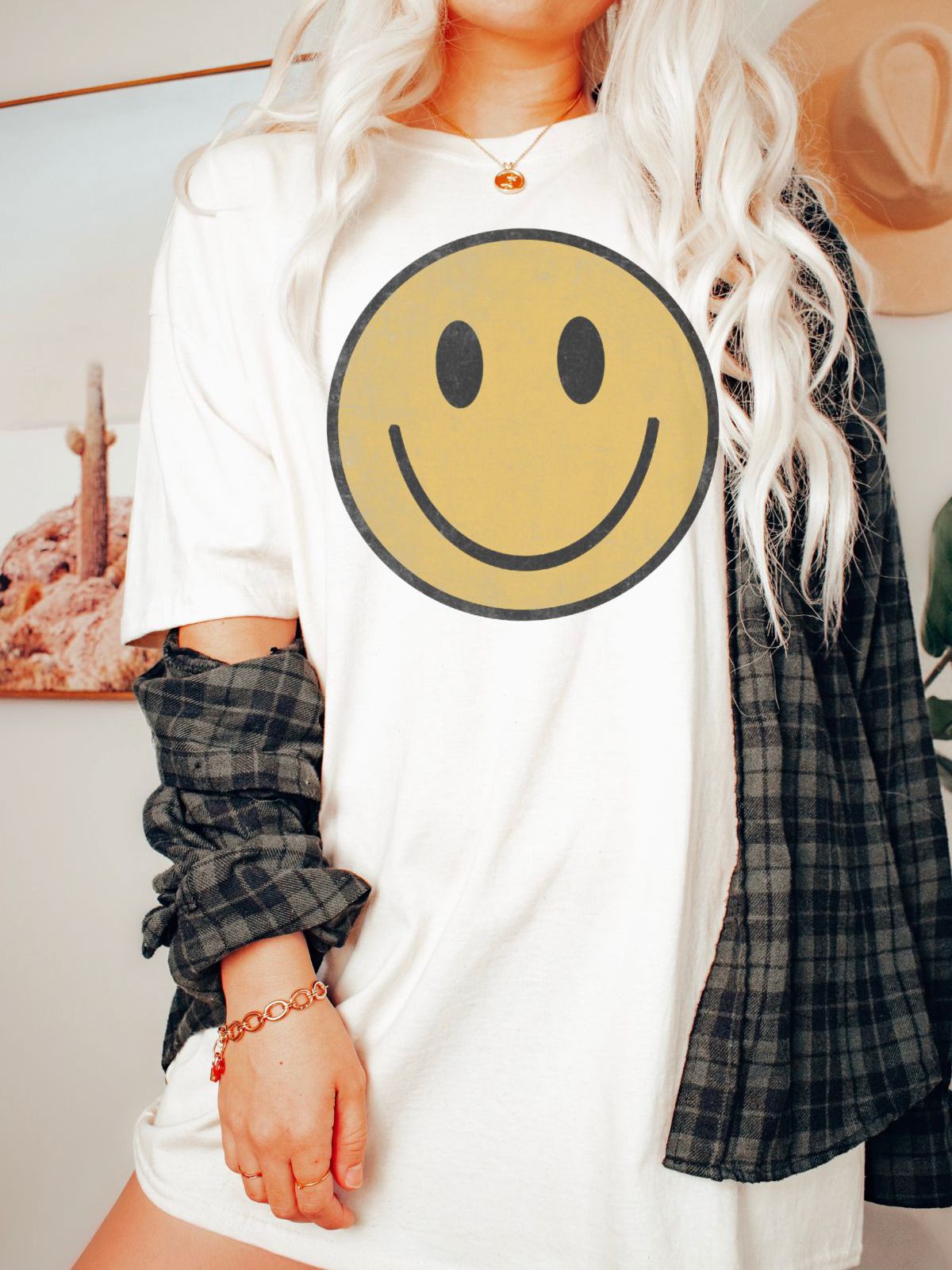 woman wearing white t-shirt with a large smiley face graphic