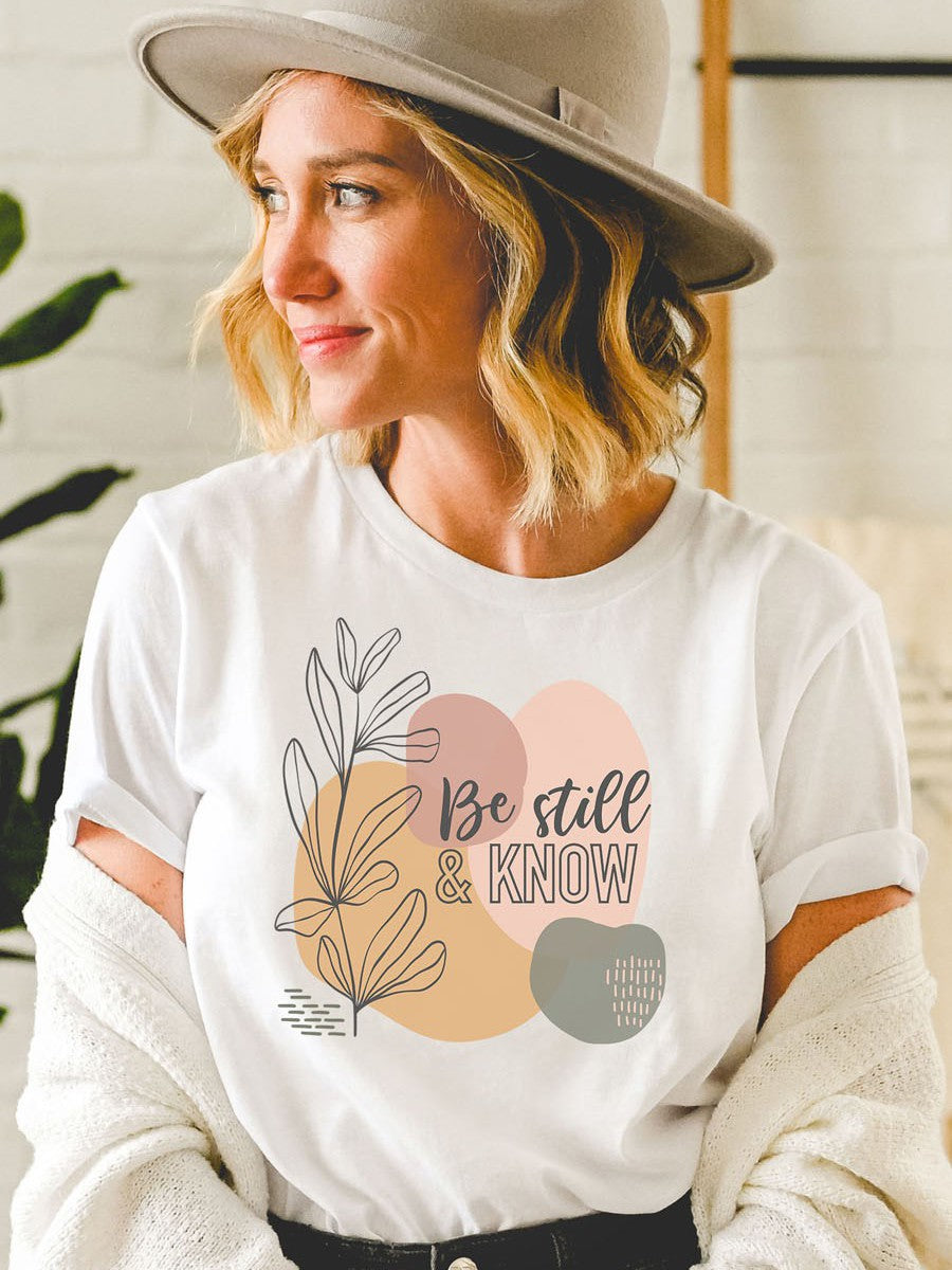 Woman wearing Be Still and Know t-shirt with abstract design