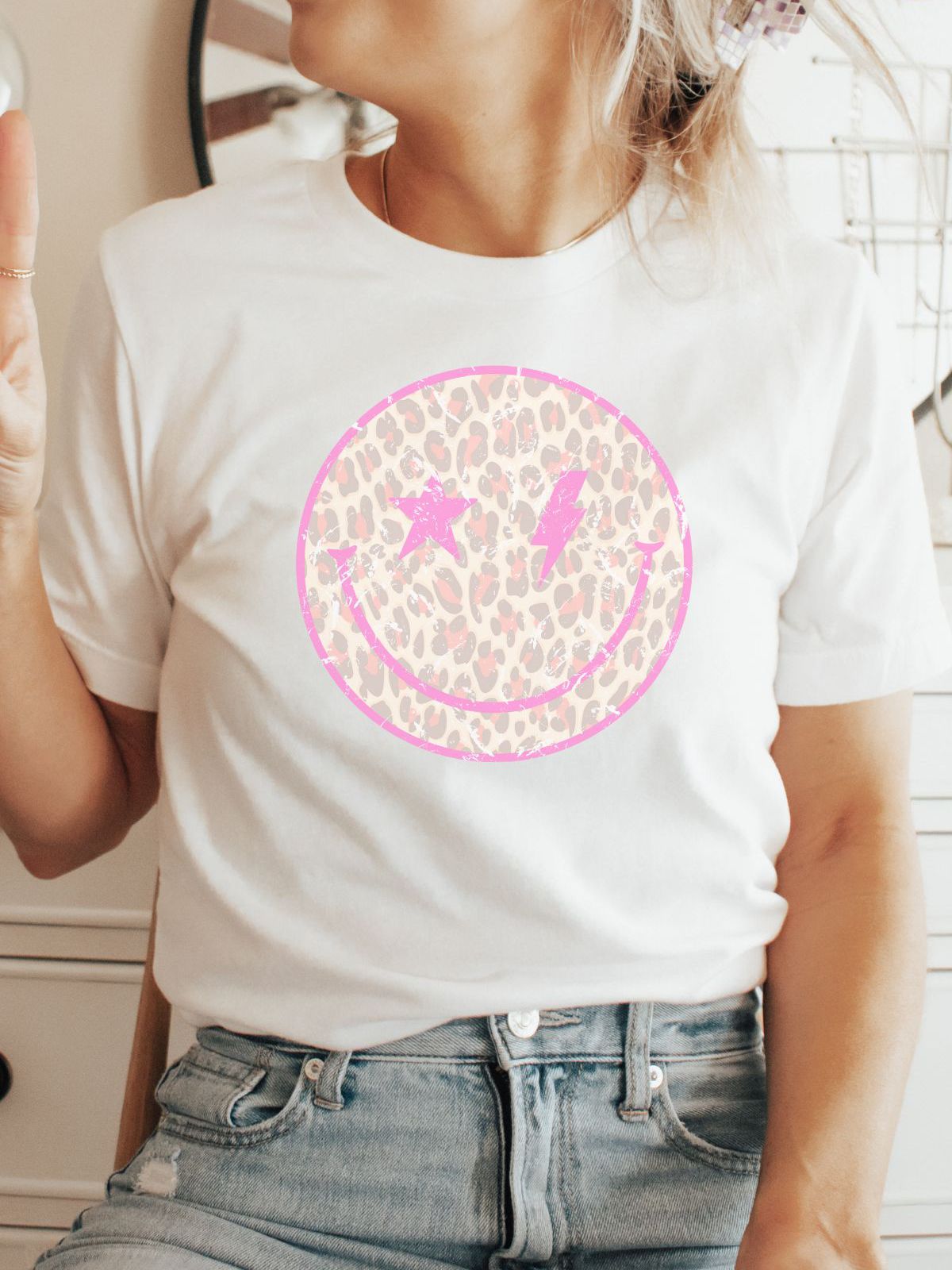 woman wearing white t-shirt with leopard smiley face design