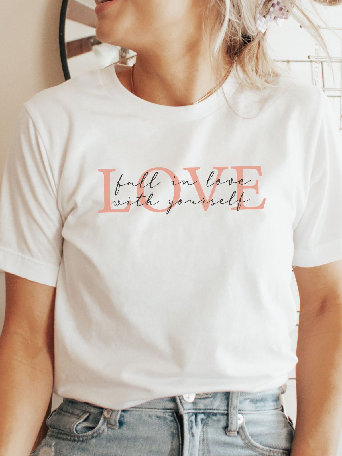 Woman wearing love themed t-shirt fall in love with yourself design