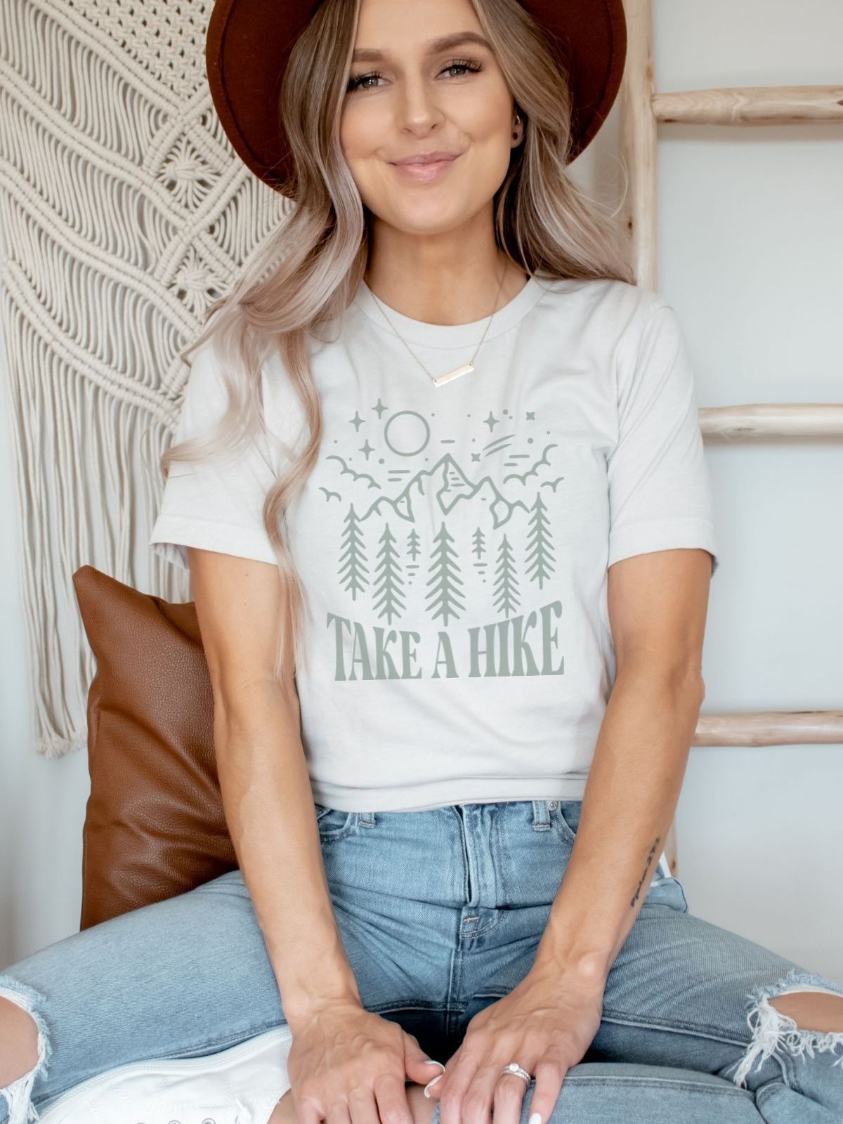 woman wearing a take a hike t-shirt with mountain design