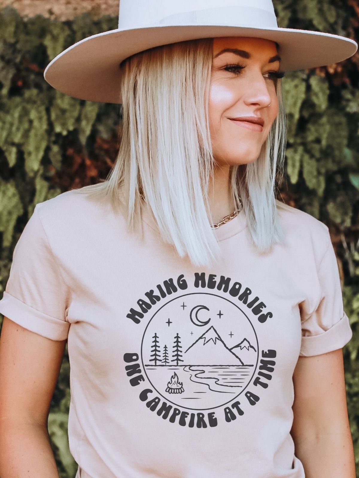 woman wearing shirt with mountain and campfire design