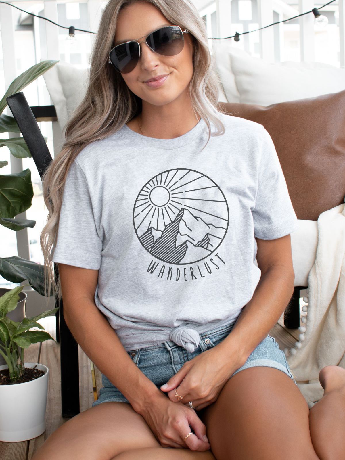woman wearing wanderlust t-shirt with mountain and sun design