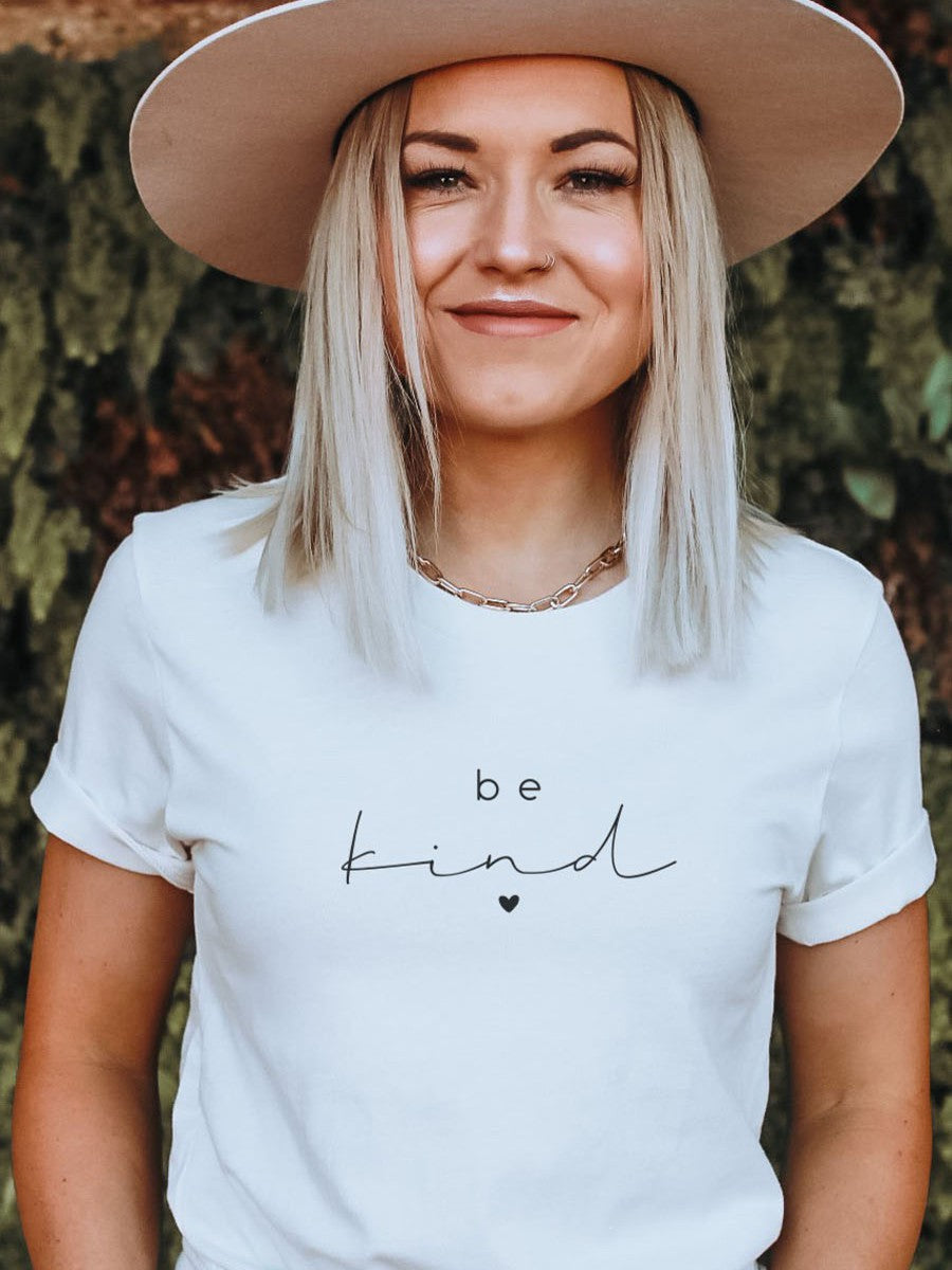 woman wearing be kind t-shirt and hat