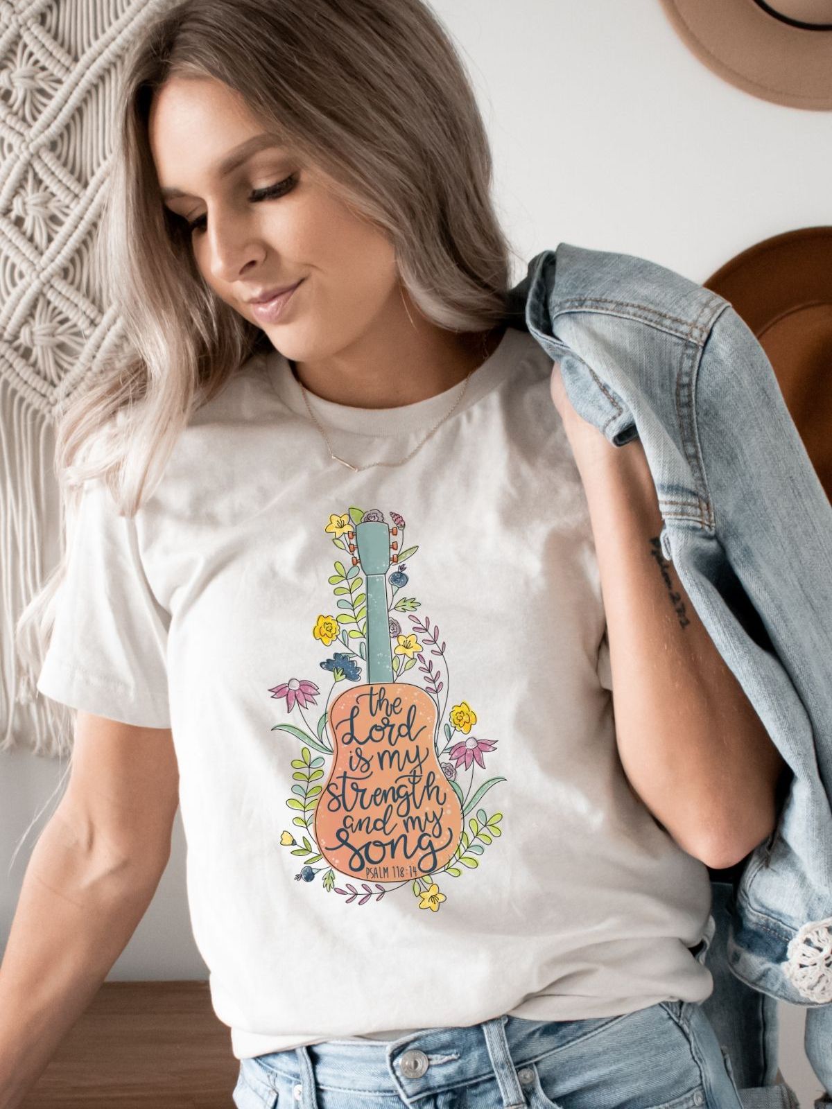 woman wearing a t-shirt with guitar and scripture design