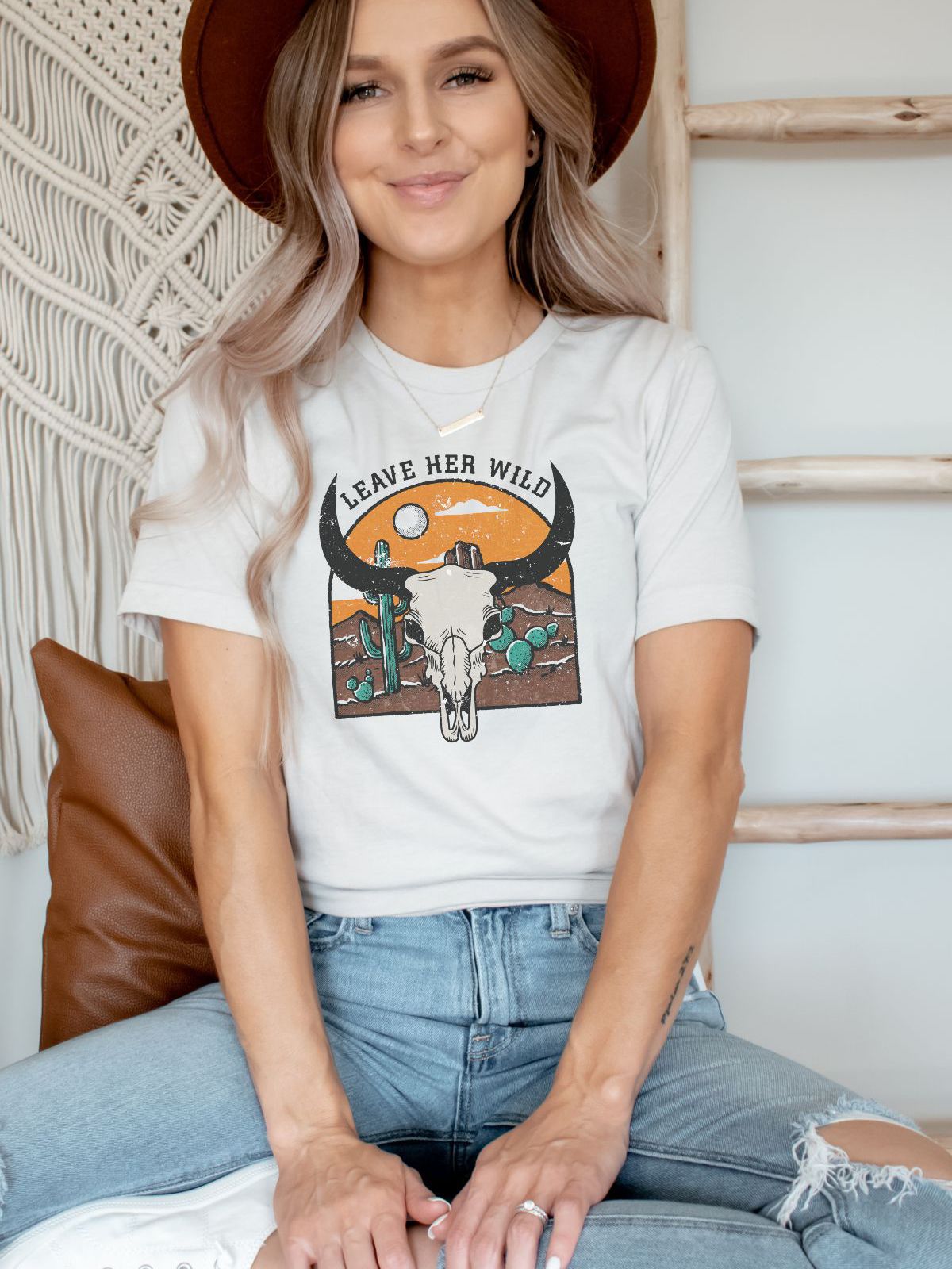 woman wearing t-shirt with leave her wild graphic