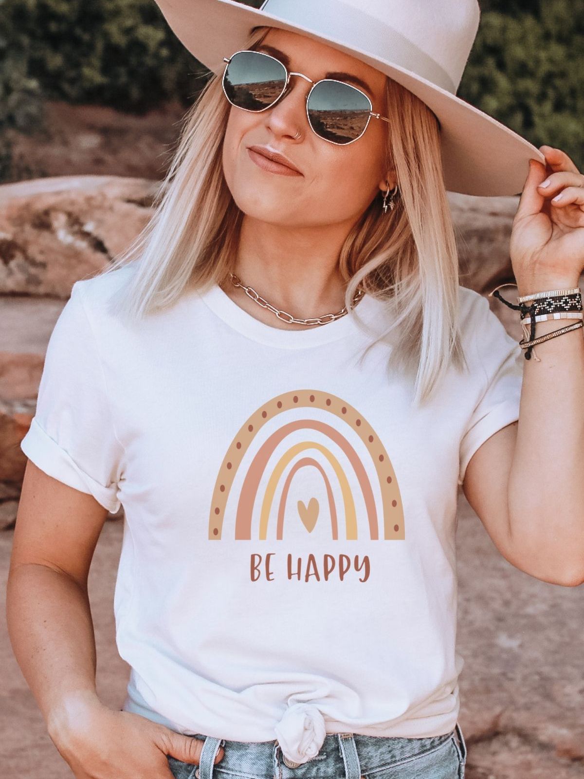 woman wearing a white tshirt with a be happy rainbow design