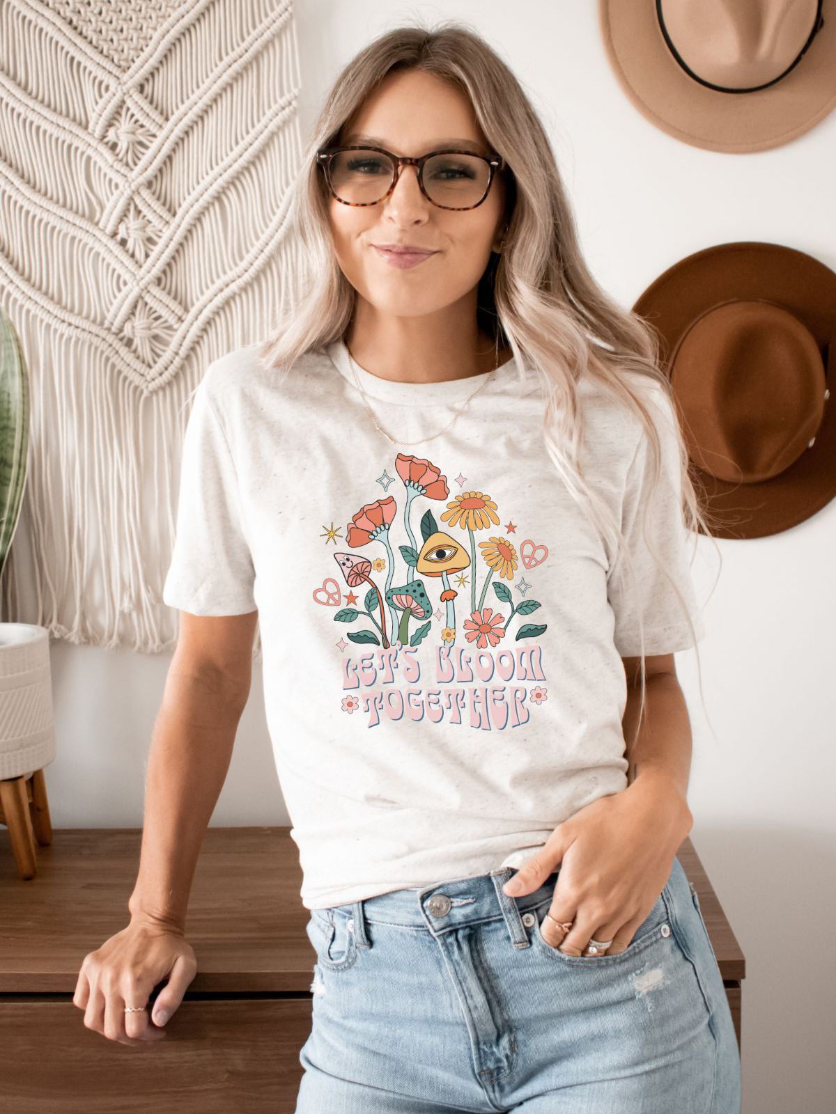 woman wearing a Let's Bloom Together t-shirt with floral design