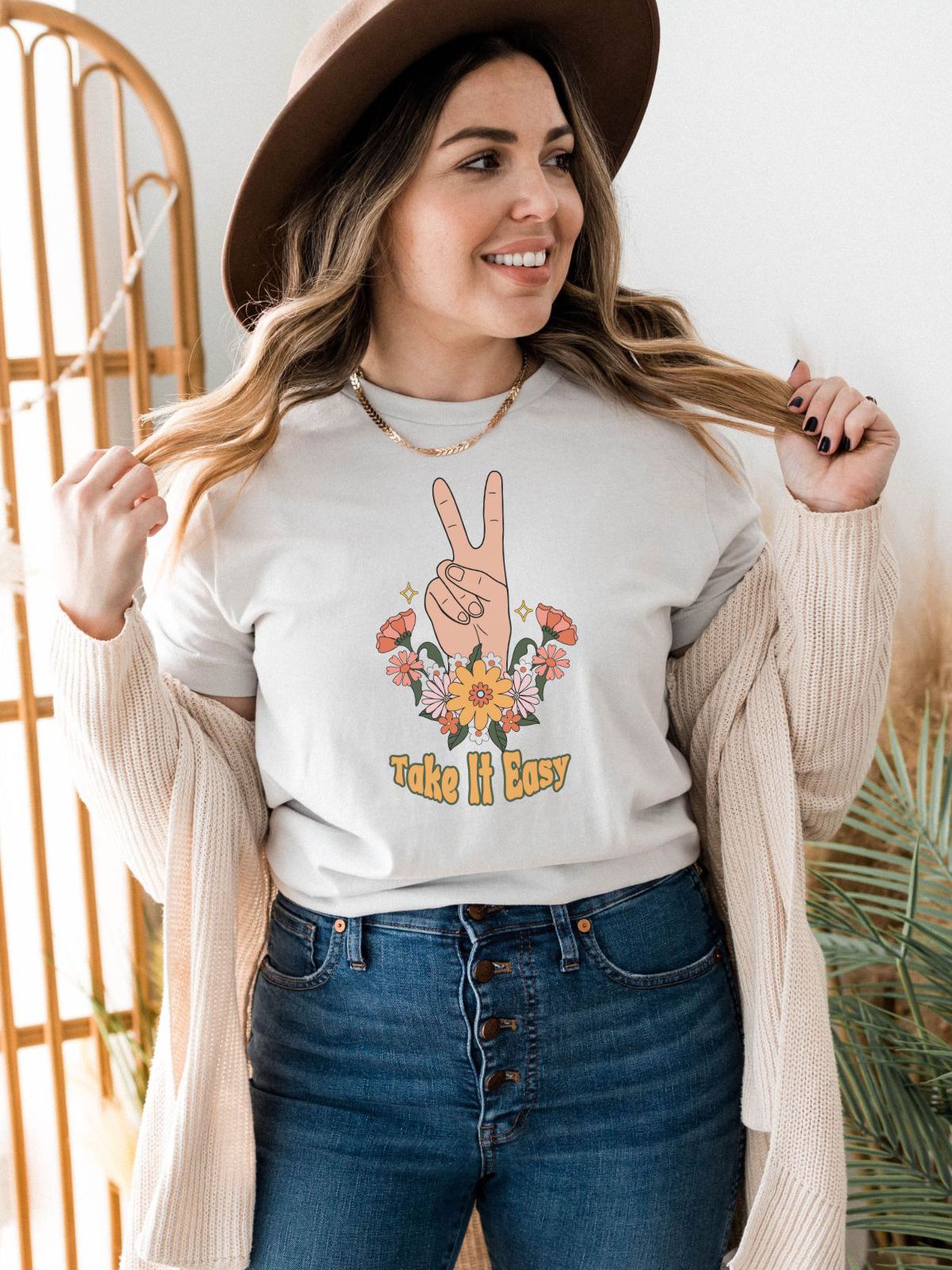 woman wearing Take it Easy graphic t-shirt with peace sign and flowers