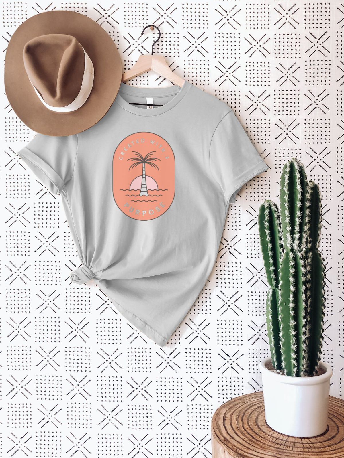 Grey t-shirt with palm tree design hanging on wall