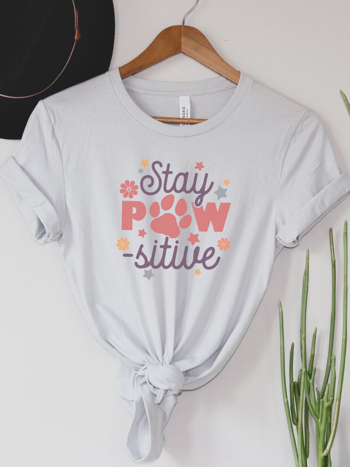 white t-shirt with Stay Pawsitive design and floral accents