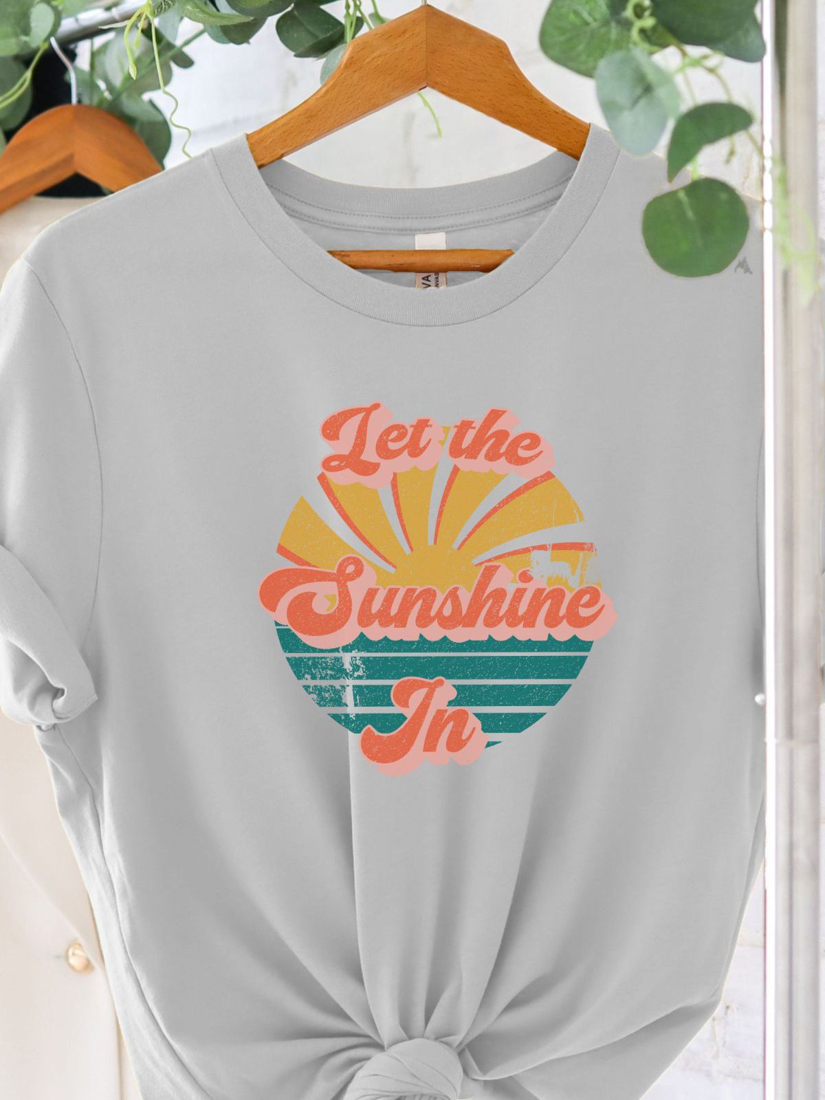 Let the Sunshine In graphic t-shirt hanging on a rack