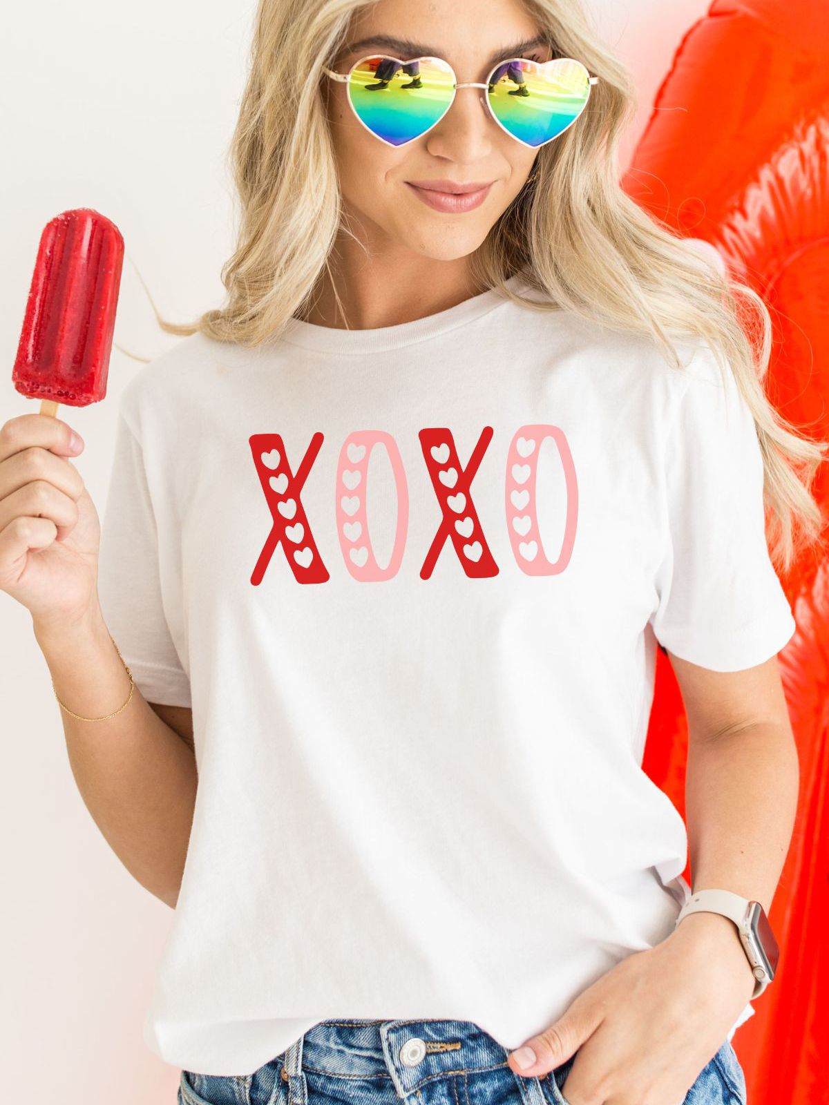 woman wearing xoxo design t-shirt holding popsicle