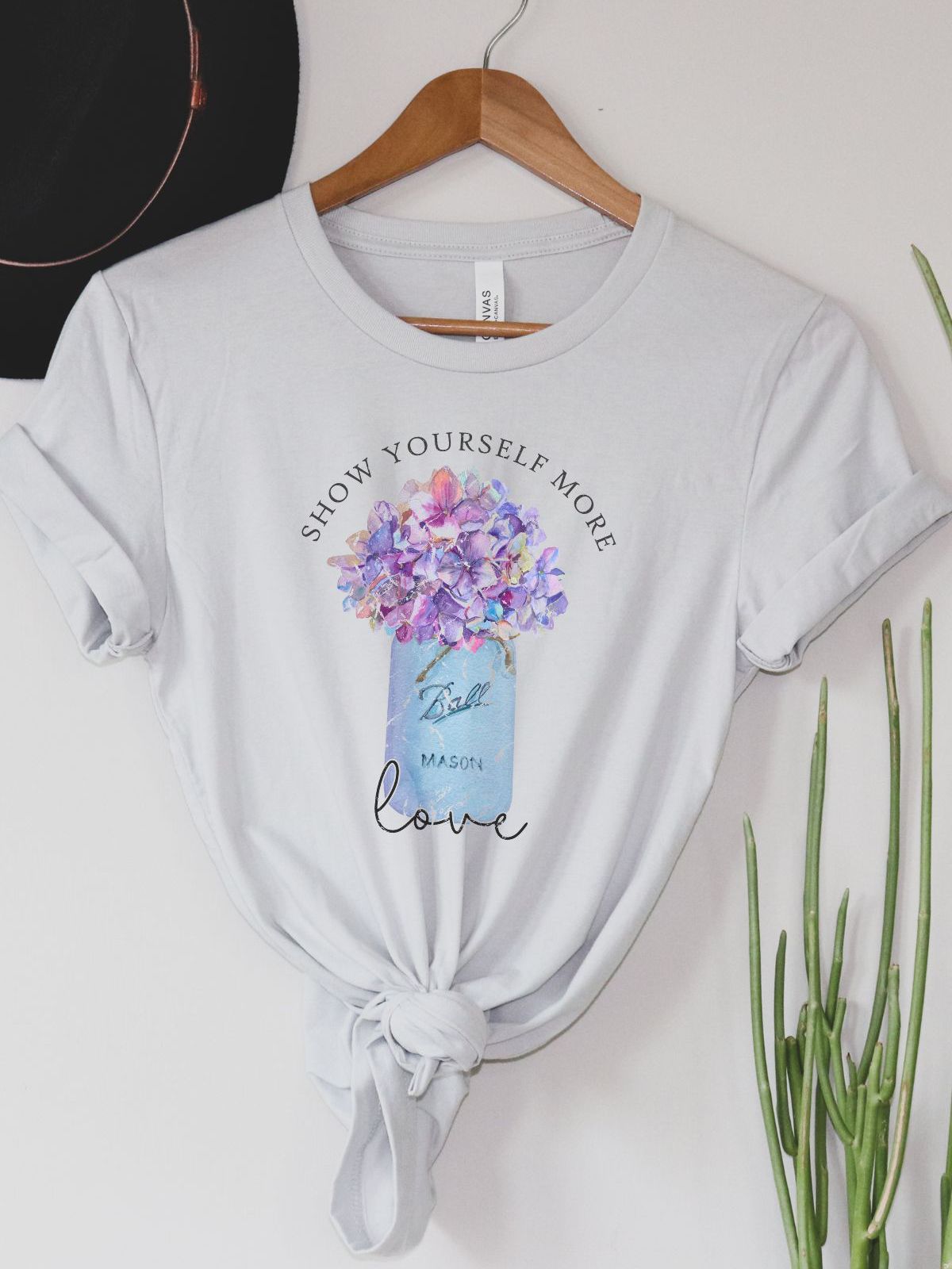 white t-shirt with flower design and the words show yourself more love
